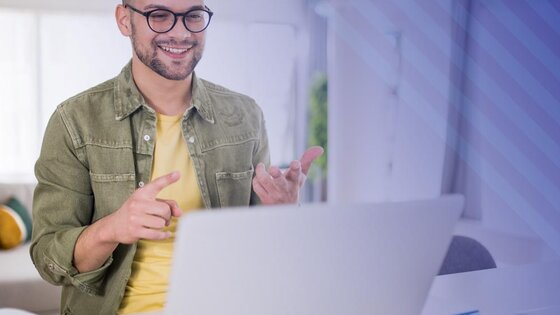 Man smiles looking at a laptop