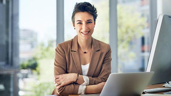 Professional woman seated at a desk with laptop