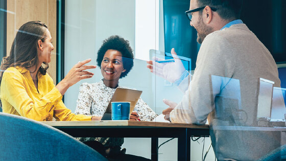 Business meeting in a conference room with multiple people.