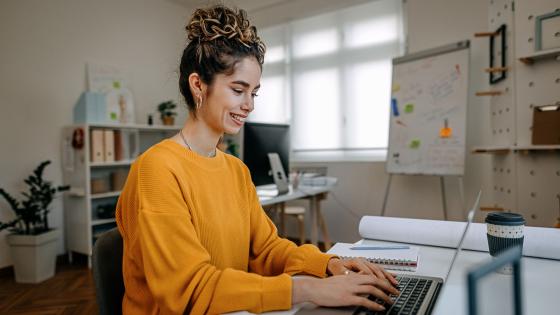 Woman sits at her computer searching for online degrees on ODUGlobal's website. Applying early can help ease your journey to online learning.