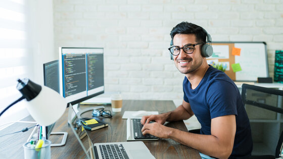 Student sitting at computer working on a software development project