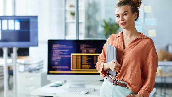 Programmer smiling in front of her computer