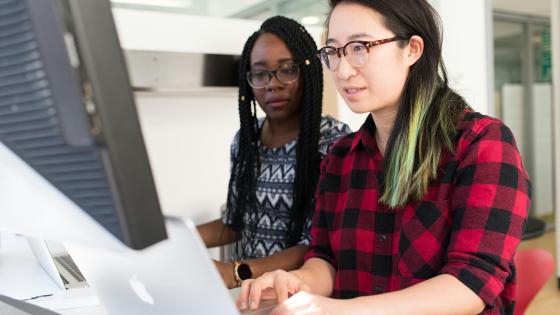 Two IT workers observing a monitor