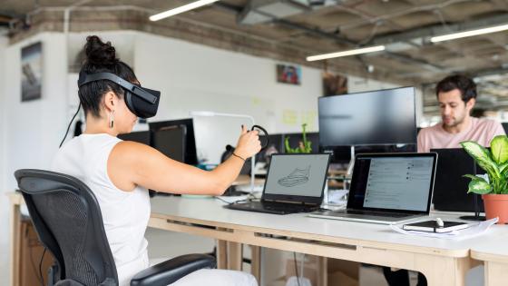 Woman with a VR headset, working on a shoe design at her computer