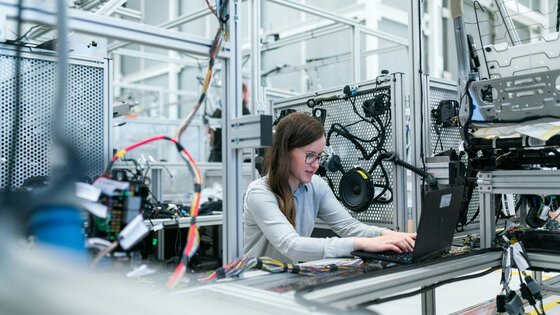 Woman sitting in an IT cage with equipment