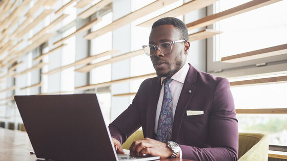 Man wearing a suit seated at a computer