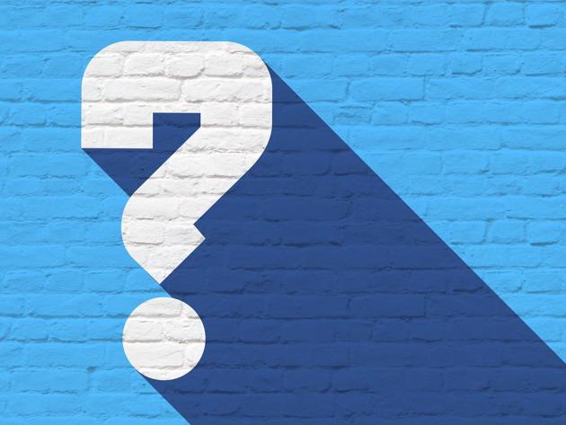 A white question mark painted on a blue brick wall.