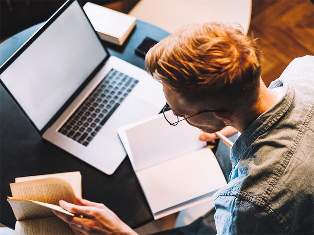 Person sitting at a computer getting organized for an online class