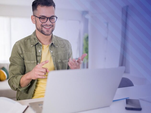 Man smiles looking at a laptop