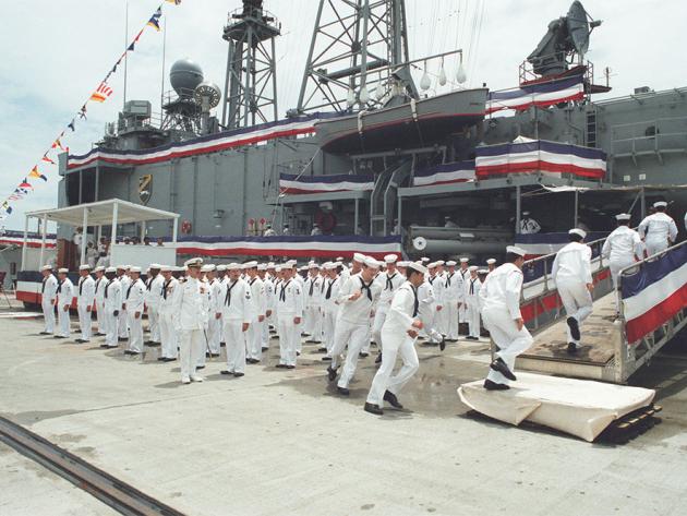 Sailors board the USS Elrod during its commissioning ceremony.