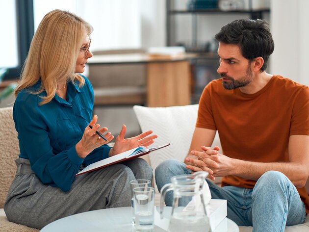 An addiction prevention and treatment specialist chats with a client in a comfortable office to support recovery.