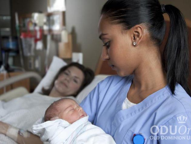 Nurse holding a baby in a hospital room