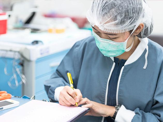 Advanced practice nurse writes notes on test results