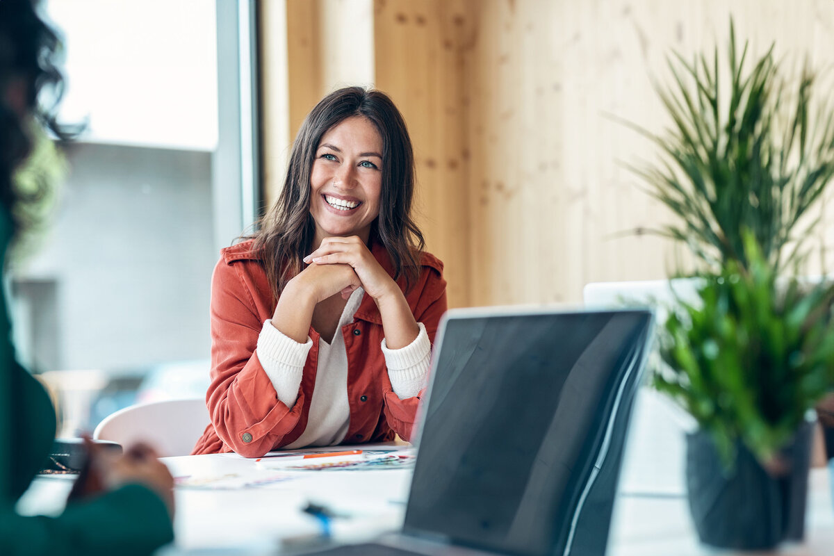 Smiling paralegal sits at a conference table in between working on briefs.